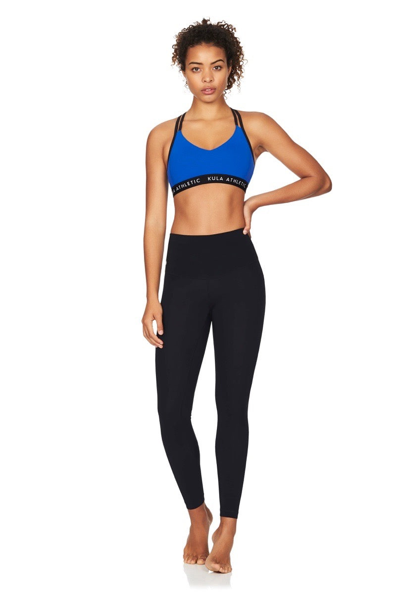 Model wearing blue sports bra and black compression yoga tights