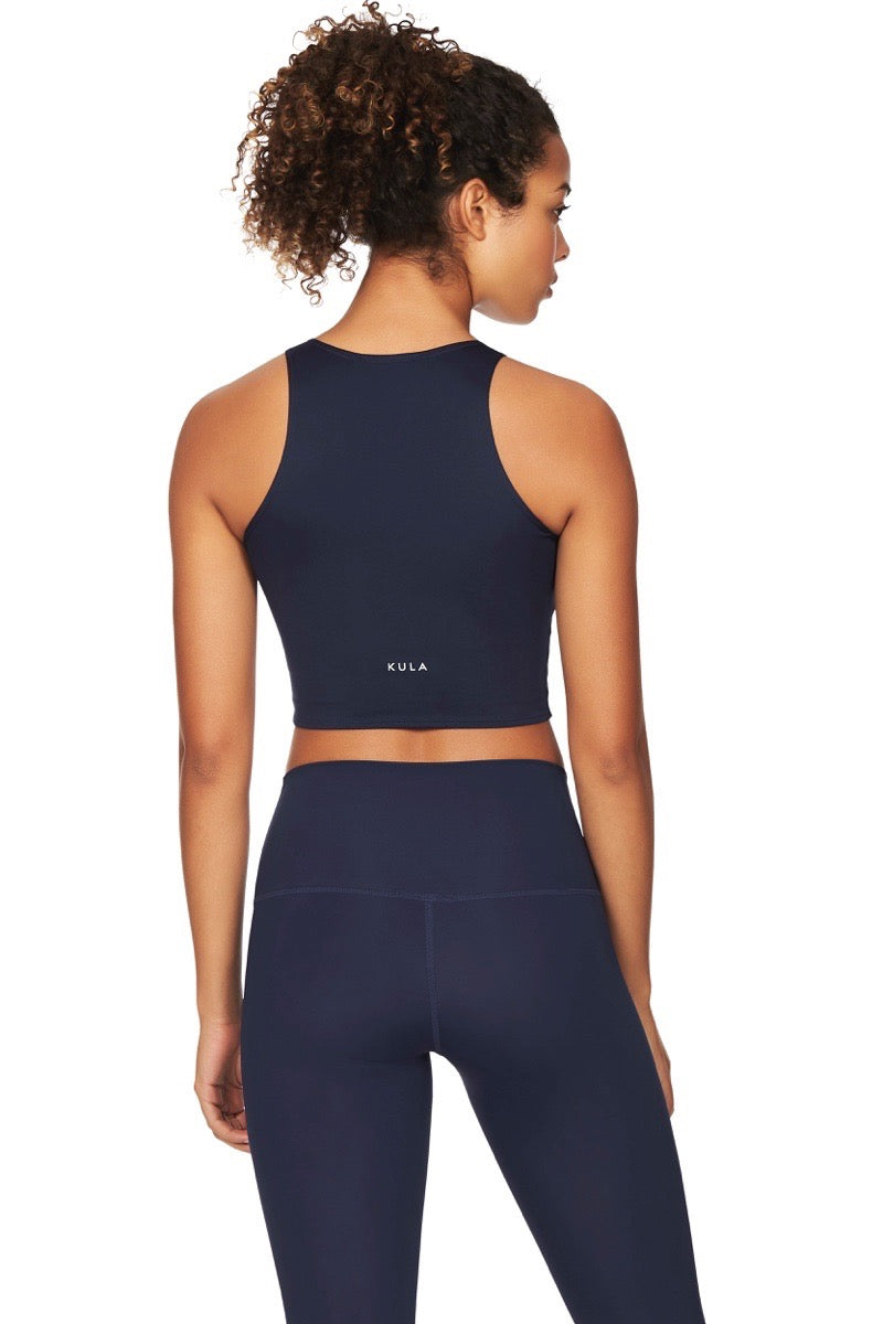 Women wearing navy blue sports crop top with logo printed in white and navy blue yoga pants
