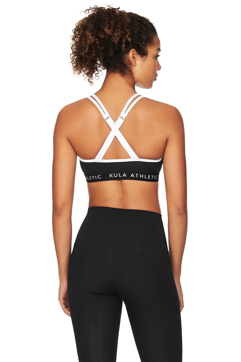 Back view of model wearing criss cross black sports bra and black compression leggings