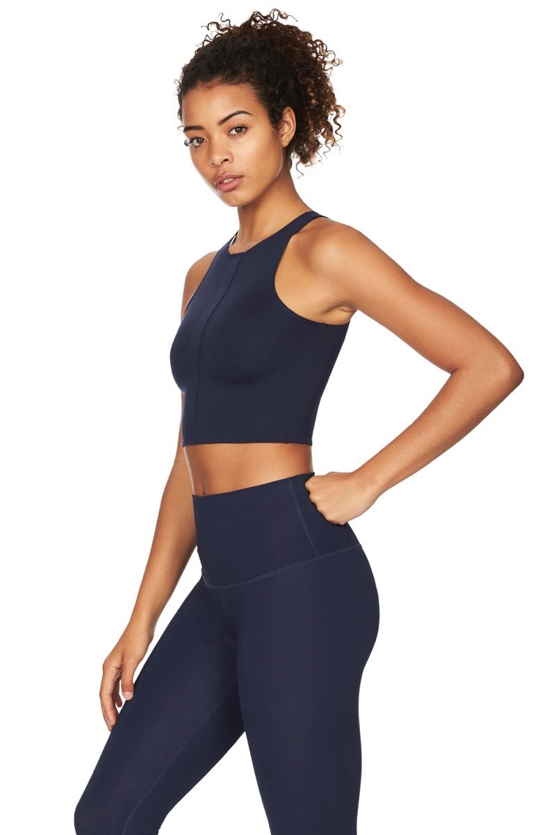 Side view of women wearing navy sports crop top with navy yoga pants