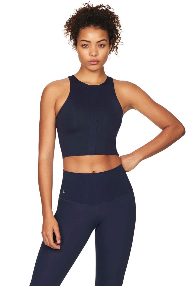 Close up shot of model wearing navy sports crop top with navy compression tights