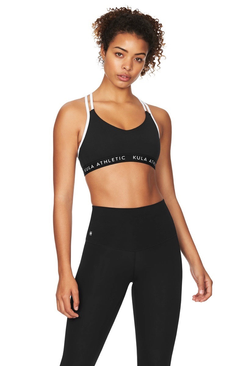 Model wearing a black v necked medium support sports bra and black yoga pants